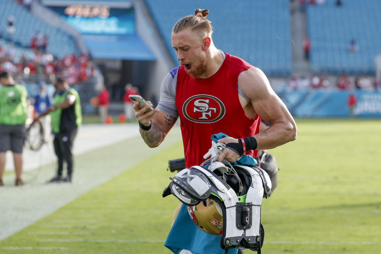 George Kittle excited by his phone.