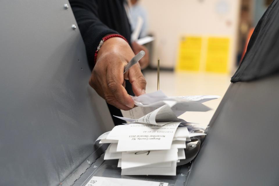 A poll worker collect voting authority cards from Westwood residents as they cast their ballots at the Westwood Community Center in Westwood, NJ on Tuesday Nov. 7, 2023.