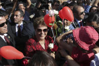 En esta foto del 6 de septiembre del 2016, la presidenta impugnada de Brasil Dilma Rousseff recibe flores y regalos de simpatizantes al salir de la residencia presidencial, el Palacio de Alvorada, en Brasilia. La nominación al Oscar de un documental brasileño sobre la impugnación de Rousseff expone una vez más la polarización de la democracia más grande de América Latina. (AP Foto/Eraldo Peres, Archivo)