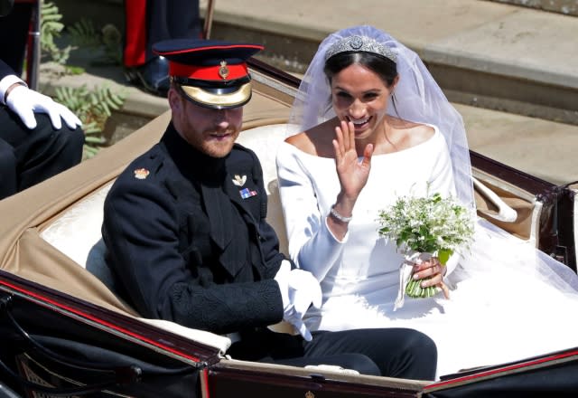 Prince Harry, Duke of Sussex and his wife Meghan, Duchess of Sussex begin their carriage procession in the Ascot Landau Carriage after their wedding ceremony at St George’s Chapel, Windsor Castle on May 19, 2018 [Photo credit should read ANDREW MATTHEWS/AFP via Getty Images]