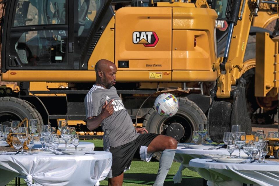 Soccer player DaMarcus Beasley navigates tables at the scene of the "Cat Trial 12: No Hands" video shoot.