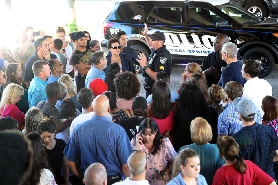 An officer tells parents waiting at Coral Springs Drive and the Sawgrass Expressway to go to the Marriott hotel to meet up with their kids from Stoneman Douglas High School.