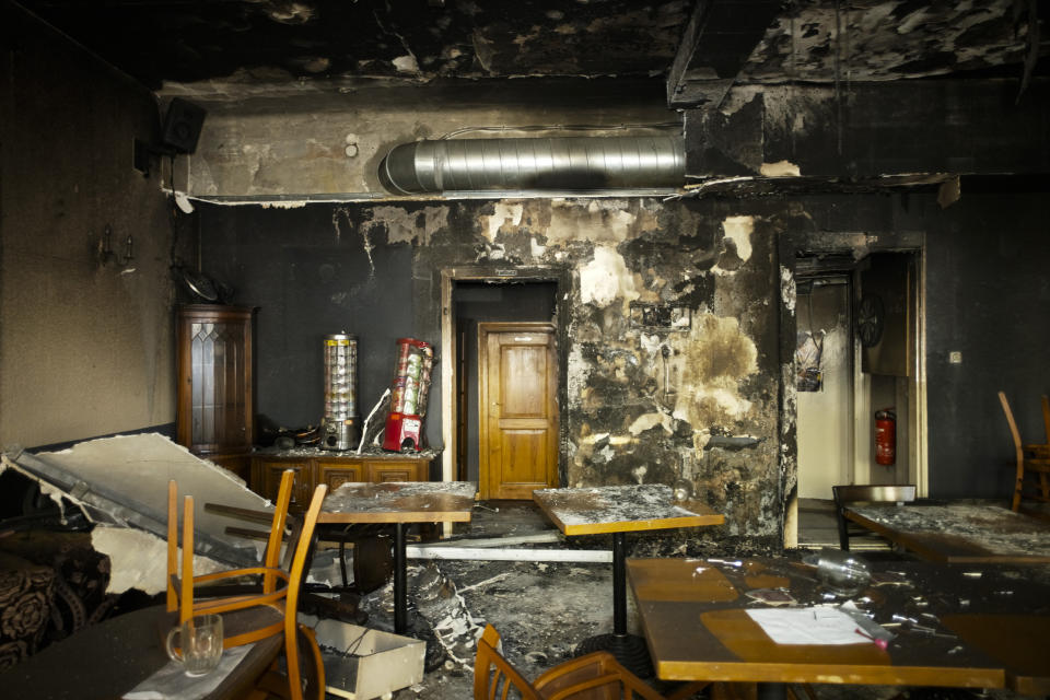 Tables and chairs stand in the burned out Jewish-run bar 'Morgen wird Besser' (Morning will be better) in Berlin, Germany, Friday, Aug. 21, 2020. The Jewish-run bar was destroyed in an arson attack on Friday, Aug. 14, 2020. The Department for Research and Information on Anti-Semitism Berlin, or RIAS documented 410 incidents in Berlin, more than two a day, in the first half of 2020, including physical attacks, property damage, threats, harmful behavior and anti-Semitic propaganda. (AP Photo/Markus Schreiber)