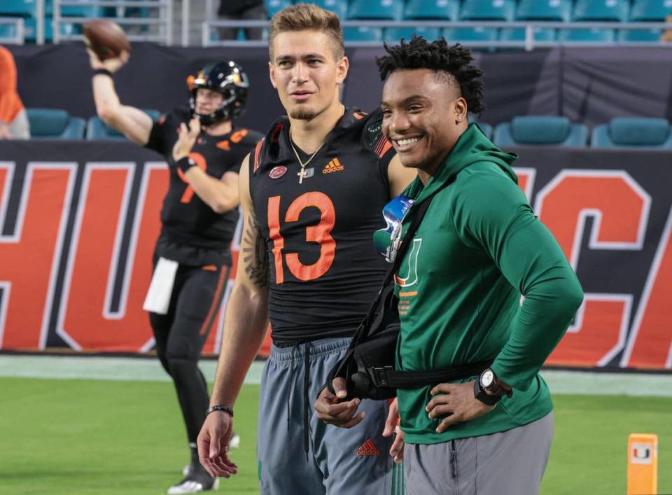 Injured quarterbacks D’Eriq King (1) and Jake Garcia (13) on the filed as starting quarterback Tyler Van Dyke (9) warms up before the start of the game against North Carolina State Wolfpack at Hard Rock Stadium in Miami Gardens on Saturday, October 23, 2021.