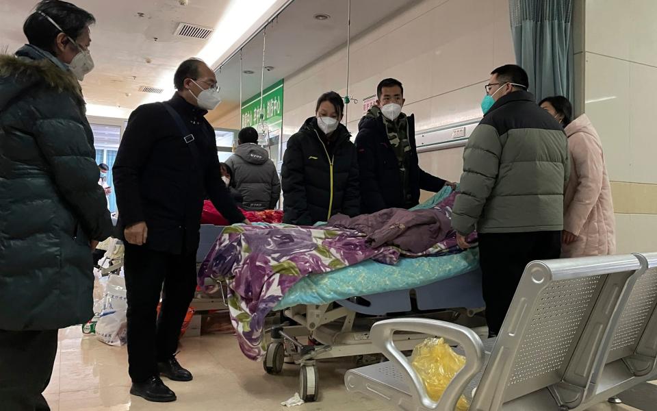 An elderly woman is surrounded by relatives in masks shortly before dying of Covid iin northern China's Hebei province