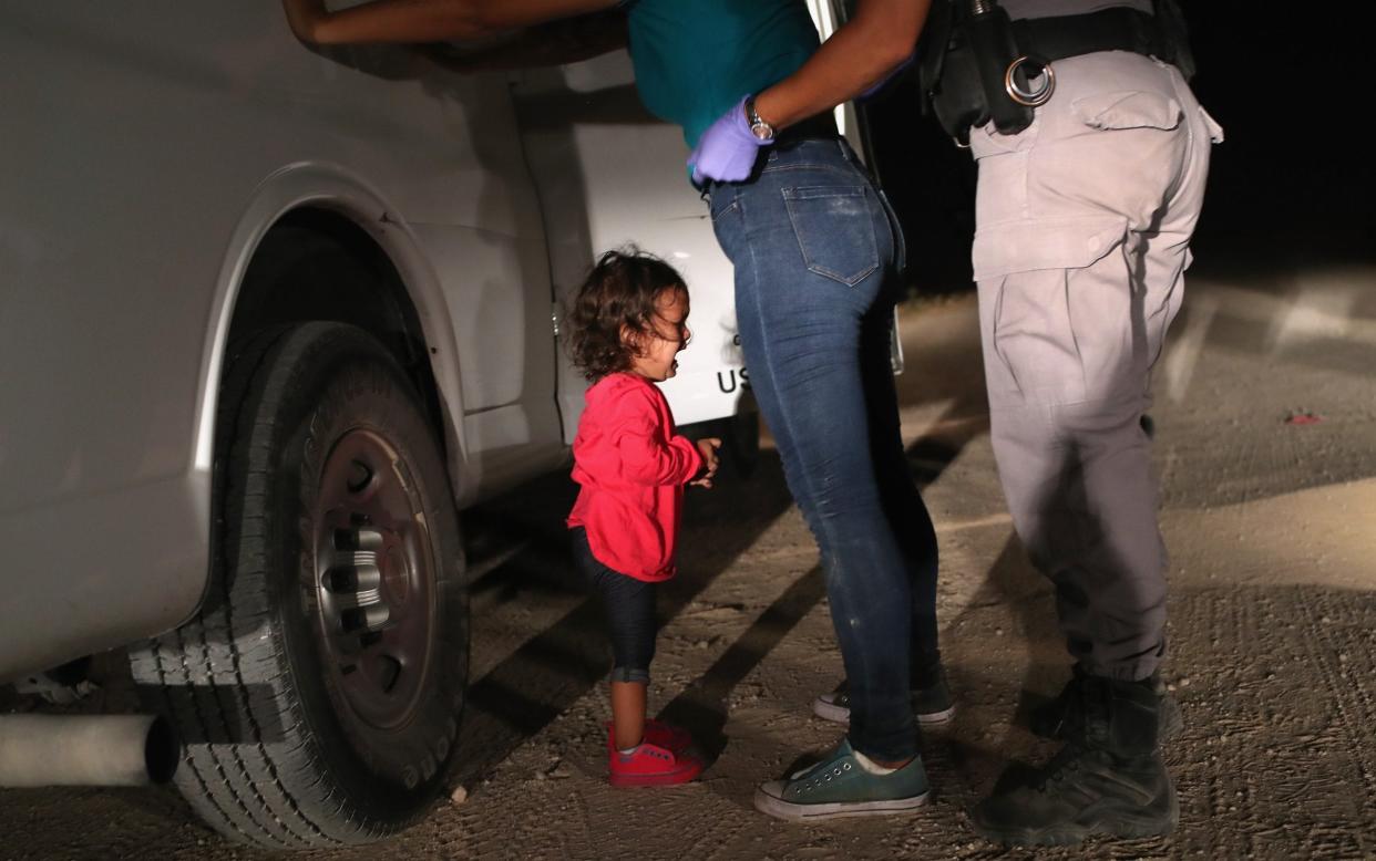 A two-year-old Honduran asylum seeker cries as her mother is searched and detained near the US-Mexico border on June 12, 2018 - Getty Images North America