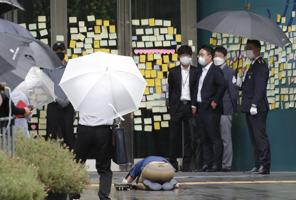 A mourner bows outside Seoul City Hall where official funeral of late Seoul Mayor Park Won-soon is held in Seoul, South Korea, Monday, July 13, 2020. Masked mourners gave speeches and laid flowers before the coffin of Seoul's mayor during his funeral Monday, while a live broadcast online drew a mixture of condolence messages and insults. (AP Photo/Lee Jin-man)