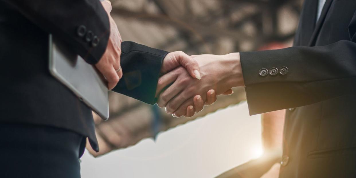 business people shaking hands over a deal to refinance a car