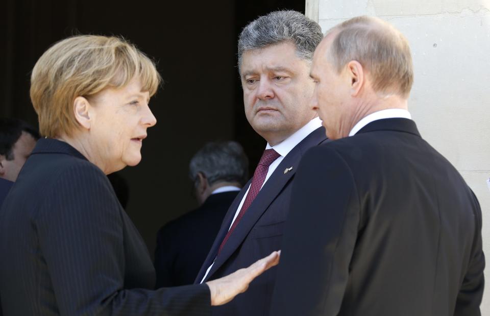 File photo of Ukraine president-elect Petro Poroshenko (C) watching as German Chancellor Angela Merkel (L) talks to Russian President Vladimir Putin during 70th anniversary of the D-Day landings at Benouville Castle, June 6, 2014. After months of ratcheting up pressure on Vladimir Putin, concern is mounting in Berlin and other European capitals that an emboldened Ukraine's military successes in the east are reducing the chances of a face-saving way out of the crisis for the Russian leader. As a result, the focus of German-led diplomatic efforts has shifted, according to senior officials, towards urging restraint from Ukrainian President Petro Poroshenko�and averting a humiliating defeat for pro-Russian rebels, a development that Berlin fears could elicit a strong response from Putin. Chancellor Angela Merkel's planned visit to Kiev August 30, 2014, her first since the crisis erupted at the start of the year, is above all a signal of support for Poroshenko, the billionaire confectionary magnate who was elected less than three months ago. REUTERS/Regis Duvignau/Files (FRANCE - Tags: POLITICS)