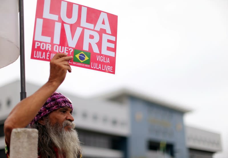 A supporter of Brazil's former president Luiz Inacio Lula da Silva shows a sign outside the Federal Police headquarters where Lula is serving a prison sentence, in Curitiba