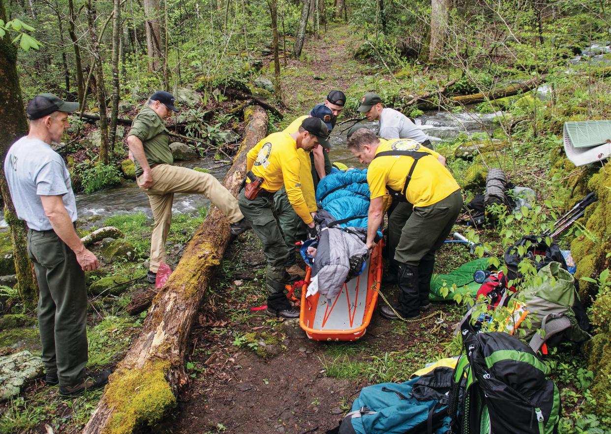 In April 2018, author David Brill and Park Librarian and Archivist Mike Aday were near the end of a long hike on the Old Settlers Trail when Aday fell while crossing a rain-swollen stream, fracturing his tibia. In the ensuing hours, both men got to experience a SAR operation first-hand. Here we see Aday being lifted onto a backboard to transport him off trail and to the road where an ambulance waited.