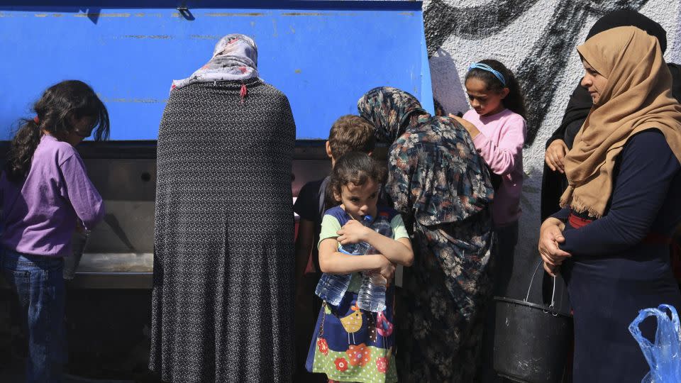 Displaced people fetch drinking water in the yard of an UNRWA school in Khan Younis, in southern Gaza, on October 20, 2023. - Mahmud Hams/AFP/Getty Images