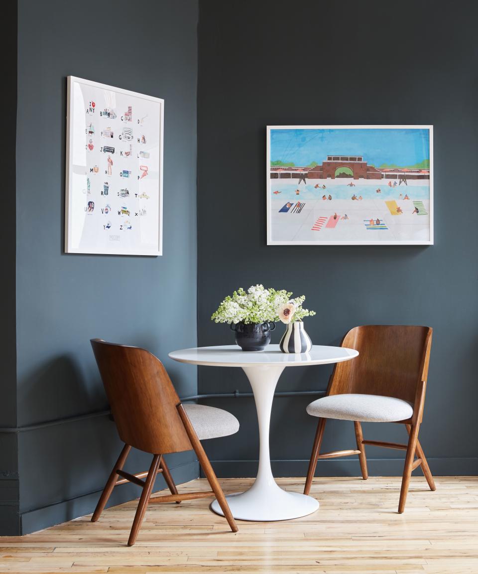 Original artwork has the power to elevate a space. These white frames contrast perfectly with the dark walls.