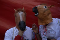 <p>Revellers in animal masks drink wine during the launch of the ‘Chupinazo’ rocket, to celebrate the official opening of the 2018 San Fermin fiestas with daily bull runs, bullfights, music and dancing in Pamplona, Spain, Friday July 6, 2018. (Photo: Alvaro Barrientos/AP) </p>