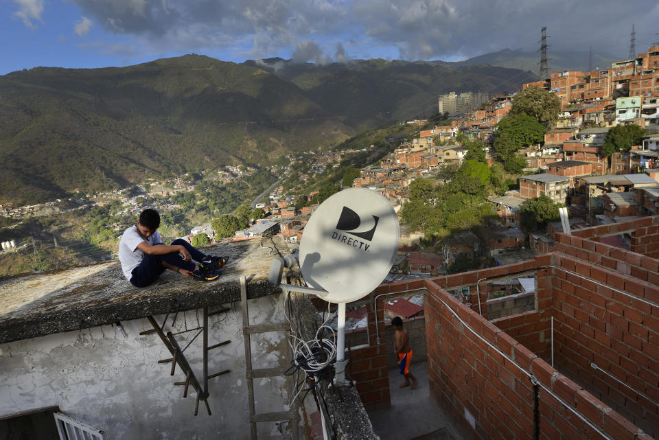 A DirectTV dish stands on home in the Catia neighborhood of Caracas, Venezuela, Thursday, Jan. 9, 2020. Venezuelan President Maduro’s opponents want AT&T’s DirecTV unit to restore a number of channels it was required to take down from its lineup. But forcing AT&T to do the political bidding of Maduro’s foes could lead to retaliation and likely exit from a market where it has a whopping 44% market share. (AP Photo/Matias Delacroix)