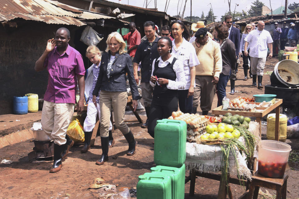 FILE - Jill Biden, wife of then-Vice President Joe Biden, third left, and her granddaughter Maisy, 9, second left, walk past a food stall as they visit the Kibera slums in Nairobi, Kenya June 8, 2010. Jill Biden is not a newcomer to Africa. It will be her sixth time in Africa when she arrives in Namibia on Wednesday as part of a commitment by President Joe Biden to deepen U.S. engagement with region. (AP Photo/Khalil Senosi)