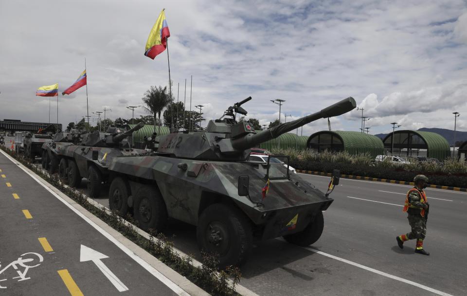 Soldiers and army tanks guard toll booths to keep protesters from damaging them, on the outskirts of Bogota, Colombia, Tuesday, May 4, 2021. Colombia’s finance minister resigned on Monday following five days of protests over a tax reform proposal that left at least 17 dead. (AP Photo/Fernando Vergara)