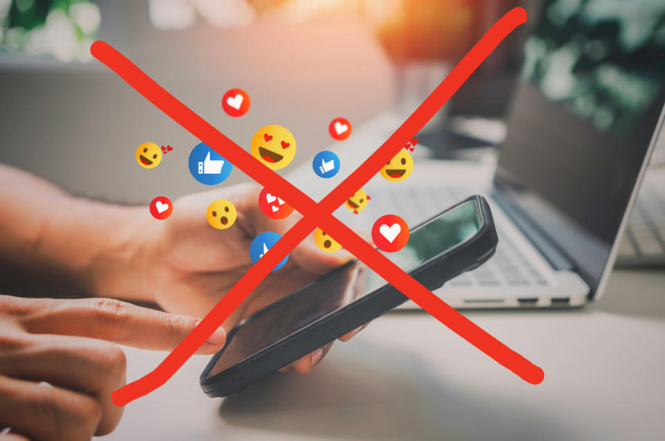 Hands holding smartphone with social media reactions floating above, large red "X" overlaid. Reflects social media rejection or ban