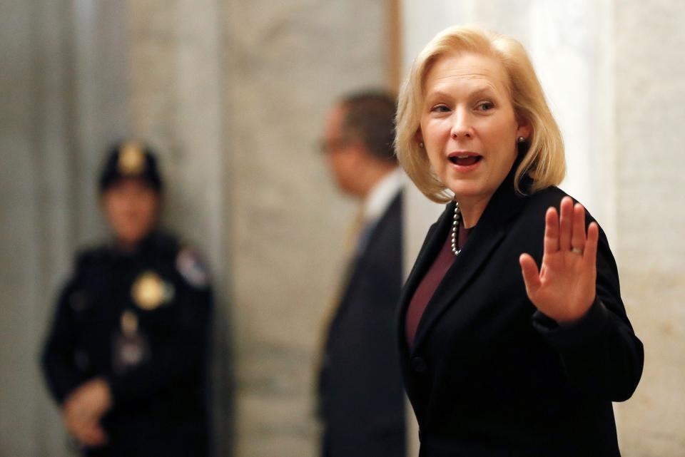 Sen. Kirsten Gillibrand, D-N.Y., waves while arriving at the Capitol in Washington during the impeachment trial of President Donald Trump on Friday.