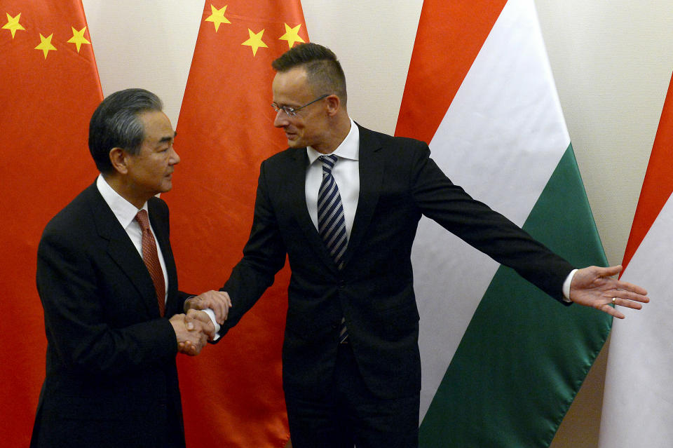 Chinese Foreign Minister Wang Yi, left, is guided by Hungarian Minister of Foreign Affairs and Trade Peter Szijjarto during their meeting in the latter's office in Budapest, Hungary, Friday, July 12, 2019. (Lajos Soos/MTI via AP)