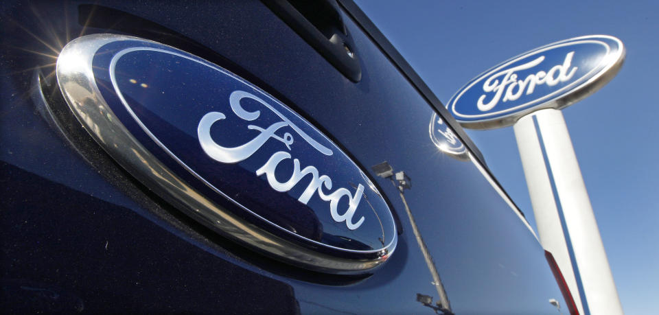 FILE - a Ford logo, on the tailgate of a 2012 F350 Super Duty pick-up truck, and Ford dealership sign are displayed at Salem Ford in Salem, N.H., on Oct. 25, 2011. Ford will add 6,200 factory jobs in Michigan, Missouri and Ohio as it prepares to build more electric vehicles and roll out two redesigned combustion-engine models, the company announced, Thursday, June 2, 2022. (AP Photo/Charles Krupa, File)