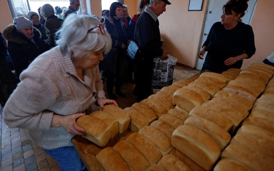 Local residents receive bread delivered by volunteers in the Russia-controlled Luhansk region of Ukraine - REUTERS/Alexander Ermochenko