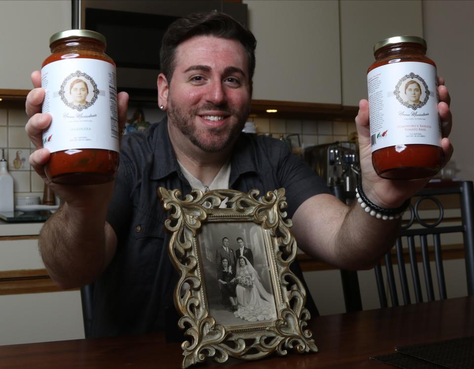 Aiello proudly holds up jars of his pasta sauce in the kitchen of his township residence.