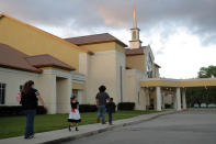 FILE - In this March 31, 2020 file photo, congregants arrive for evening service at the Life Tabernacle Church in Central, La. Pastor Tony Spell held services despite being charged with misdemeanors for holding services against Gov. John Bel Edwards shelter-in-place order due to the new coronavirus pandemic. Where political divides marred early recovery efforts after Hurricane Katrina in 2005, Louisiana is showing rare political unity in the fight against the new coronavirus. (AP Photo/Gerald Herbert, File)