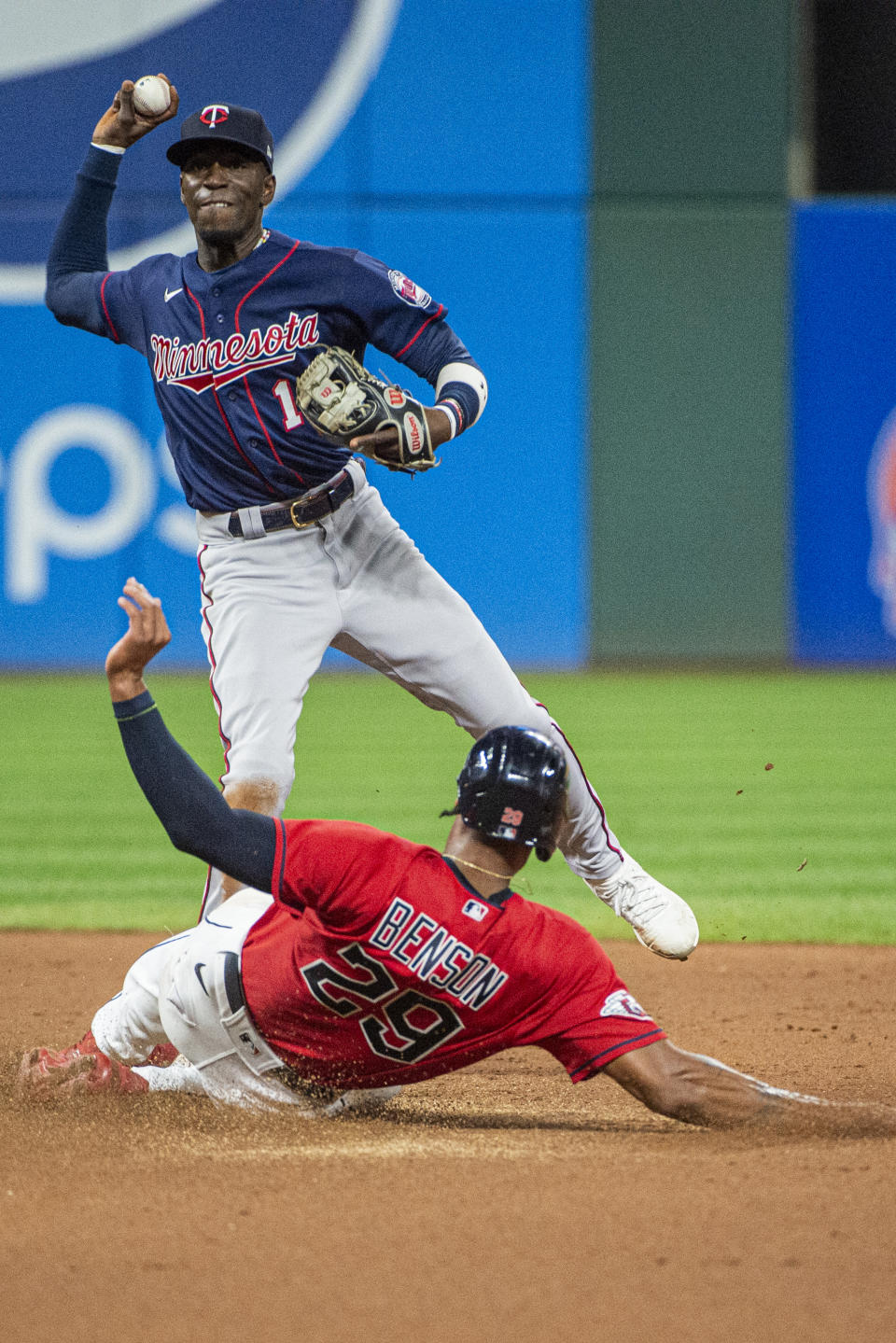 Minnesota Twins' Nick Gordon, top, forces out Cleveland Guardians' Will Benson (29) at second base and completes a double play by throwing out Luke Maile at first during the fifth inning of the second game of a baseball doubleheader in Cleveland, Saturday, Sept. 17, 2022. (AP Photo/Phil Long)