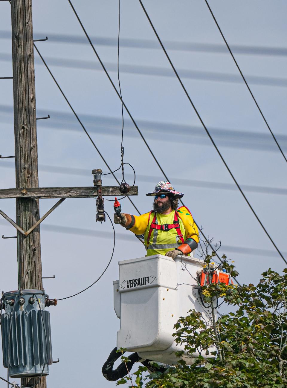 Lineman Bo Turner from Praxel Line Services in Kentucky works to restore electricity along Teel Avenue in Lansing Tuesday, Aug. 29, 2023. A major storm last Thursday night caused widespread damage to the area and left thousands without electricity.