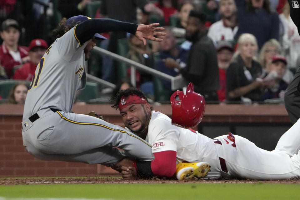 St. Louis Cardinals' Willson Contreras is tagged out by Milwaukee Brewers starting pitcher Freddy Peralta, left, at home during the second inning of a baseball game Friday, April 19, 2024, in St. Louis. (AP Photo/Jeff Roberson)