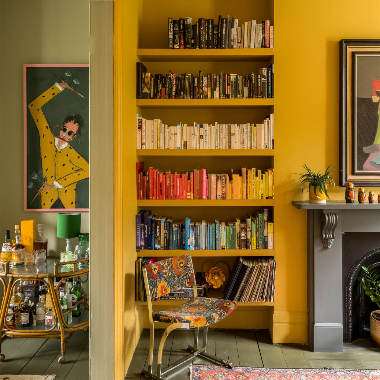  Open plan living room with one room painted in yellow and the other in green. 