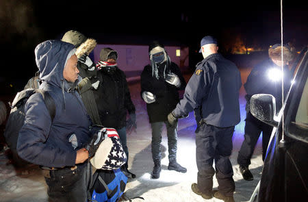 Refugees that walked along railway tracks from the United States to enter Canada are detained by the Royal Canadian Mounted Police at Emerson, Manitoba, Canada February 26, 2017. REUTERS/Lyle Stafford