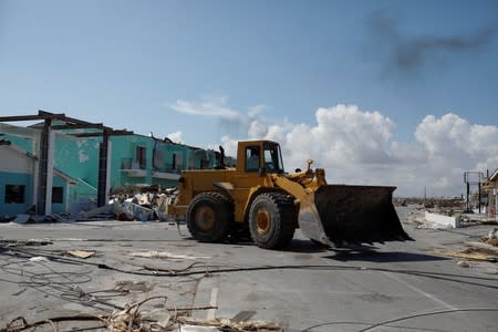 A worker in a bulldozer cleans debris from the parking lot of a private shopping center after Hurricane Dorian hit the Abaco Islands in Marsh Harbour