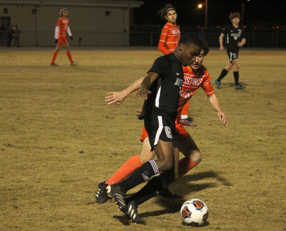 Bartram Trail midfielder Dimani Mathlin (6) dribbles the ball as Mandarin fullback Sergey Rakhamimov (21) defends.