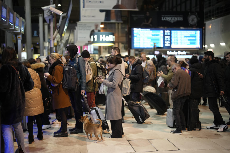 Commuters wait to board a train at the Gare de Lyon station Tuesday, Feb. 7, 2023 in Paris. The French parliament has started debating President Emmanuel Macron's unpopular pension reform proposals, which prompted strikes and large demonstrations in recent weeks. The bill would raise the minimum retirement age from 62 to 64. A third round of protests has been called on Tuesday Feb.7, 2023 by eight main workers' unions. (AP Photo/Christophe Ena)