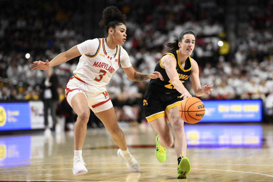 Iowa guard Caitlin Clark, right, passes the ball against Maryland guard Lavender Briggs (3) during the first half of an NCAA college basketball game, Saturday, Feb. 3, 2024, in College Park, Md. (AP Photo/Nick Wass)