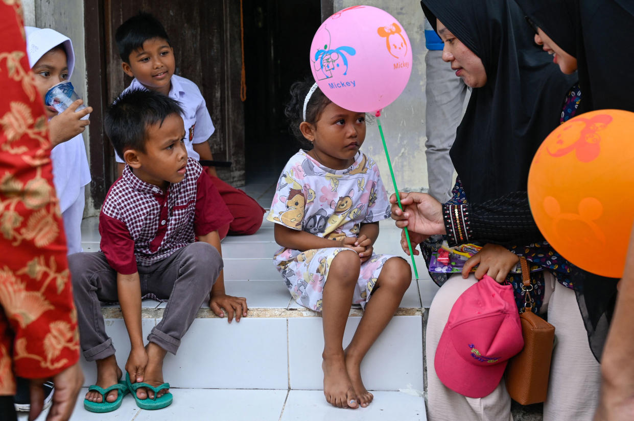 A health worker hands a balloon to a child after she was administered the polio vaccine during a vaccination drive in Pulo Aceh, a remote island in Aceh province, Indonesia, on Dec. 6, 2022.