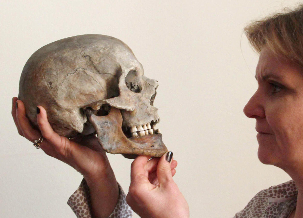 Forensic pathologist Constanze Niess holds up the approximately 700-year-old skull of a man from the now-submerged city of Rungholt in 2016. (Wolfgang Runge via Getty Images)