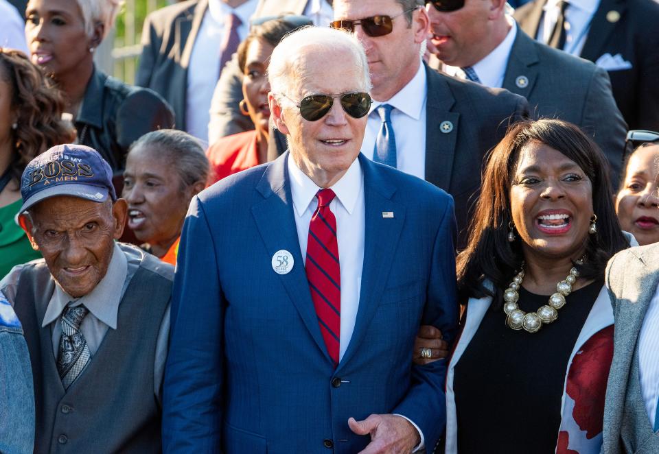 President Joe Biden is flanked by foot soldier George Sallie, left. and Rep. Terri Sewell, right as he marches across the Edmund Pettus Bridge in Selma, Ala., on Sunday March 5, 2023 to commemorate the 58th anniversary of the Bloody Sunday bridge crossing.