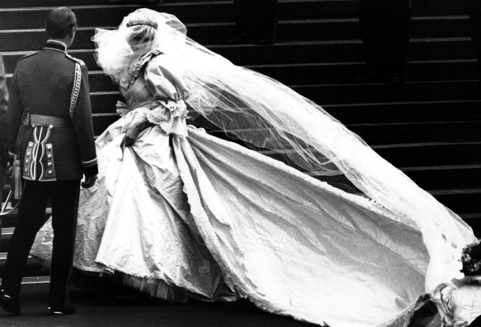 Lady Diana Spencer, soon to become the Princess of Wales, showing her wedding gown for the first time, turns as her bridesmaids set her train on arrival at Saint Paul's Cathedral for her wedding to Prince Charles in London, July 29, 1981. REUTERS/Mal Langsdon (BRITAIN  - Tags: ENTERTAINMENT ROYALS) BEST QUALITY AVAILBLE