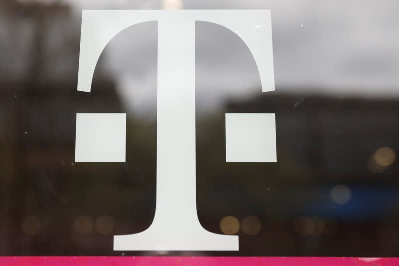 A T-Mobile logo is seen on the storefront door of a store in Manhattan