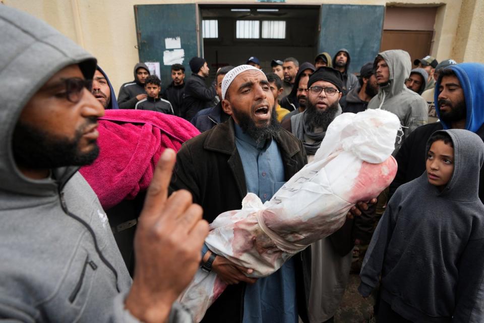 Palestinians chant Islamic slogans while carry the bodies of children killed in the Israeli strikes in the Gaza Strip in front of the morgue at Al Aqsa hospital (Copyright 2024 The Associated Press. All rights reserved.)