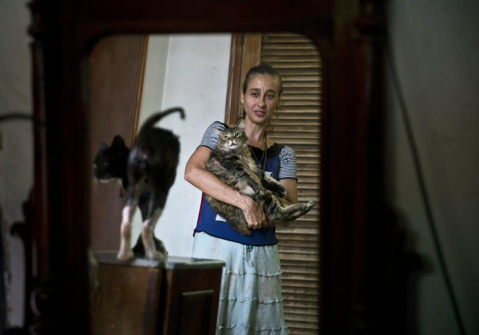 In this Thursday, April. 4, 2019 photo, Grettel Montes de Oca Valdes, a professional dancer and founder of the group Cubans in Defense of Animals poses with cats that were strays in her home in Havana, Cuba. A group of animal-lovers will march a mile down one of Havana’s main thoroughfares Sunday waving placards calling for an end to animal cruelty in Cuba. Short, seemingly simple, the march will write a small but significant line in the history of modern Cuba. (AP Photo/Ramon Espinosa)