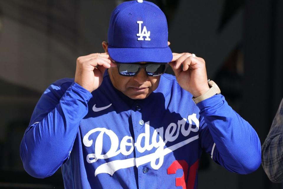 Dodgers manager Dave Roberts puts on his sunglasses as he walks out of the clubhouse at Camelback Ranch on Thursday.