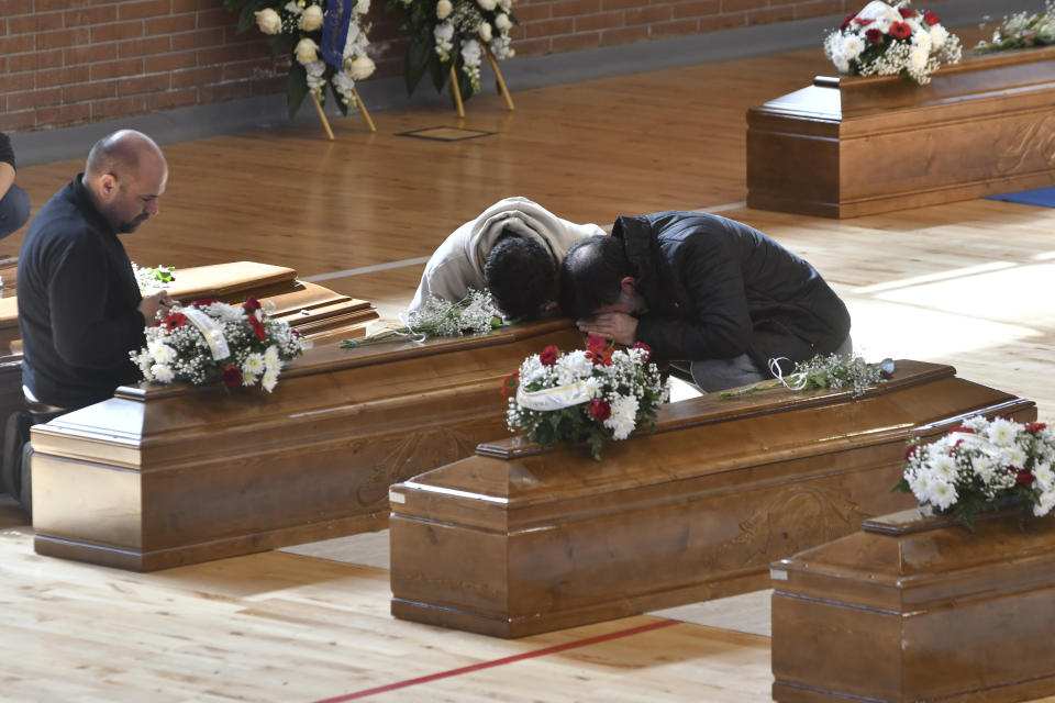 Relatives cry on the coffin of one of the victims of last Sunday's shipwreck at the local sports hall in Crotone, southern Italy, Wednesday, March 1, 2023. Nearly 70 people died in last week's shipwreck on Italy's Calabrian coast. The tragedy highlighted a lesser-known migration route from Turkey to Italy for which smugglers charge around 8,000 euros per person. (AP photo/Giuseppe Pipita, File)