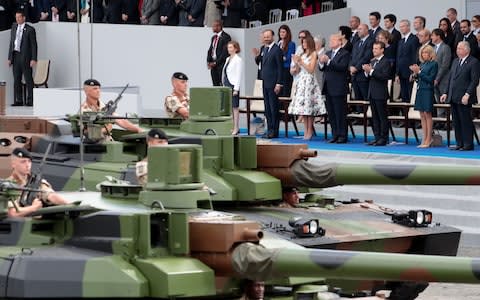 Donald Trump admires a military parade in Paris last year - Credit: AFP