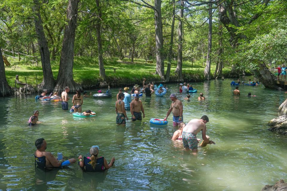Visitors swim in Cypress Creek at Wimberley Blue Hole Regional Park on July 30. Blue Hole has remained open to swimmers, though the swimming hole is only about 65% filled.