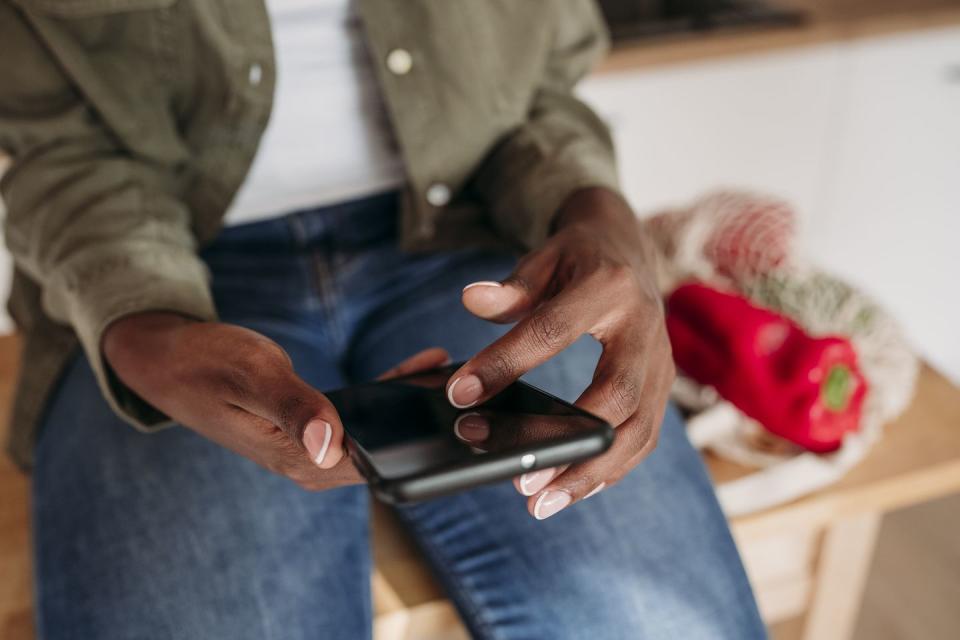 woman scrolling smart phone at home