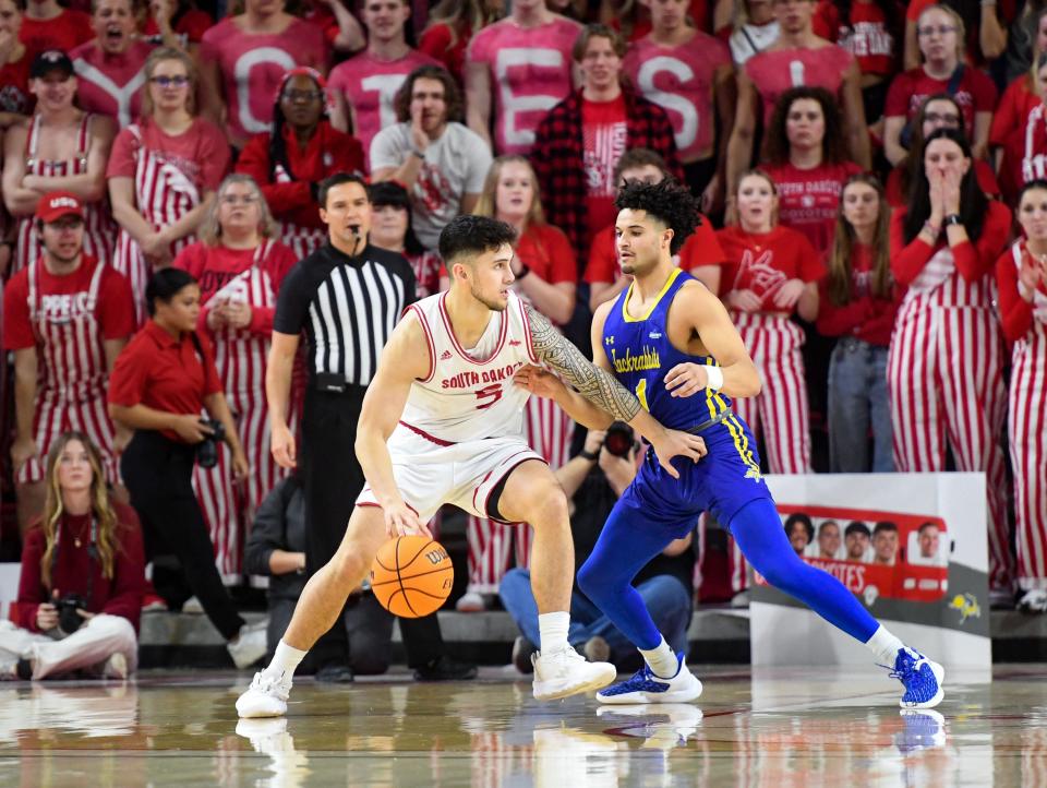 South Dakota’s Kruz Perrott-Hunt pushes against South Dakota State’s Matt Mims in a rivalry matchup on Saturday, January 14, 2023, at the Sanford Coyote Sports Center in Vermillion.